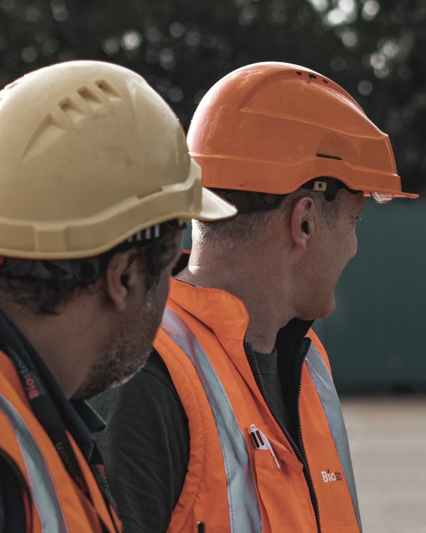 Professional tradespeople wearing safety helmets and hi-vis gear on site